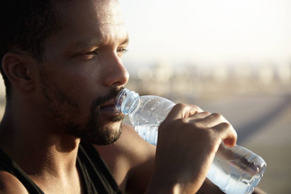 man drinking water outside