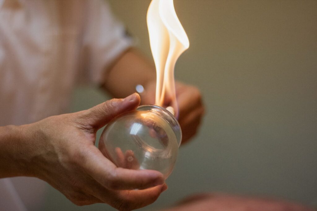 woman prepping glass cup for fire cupping