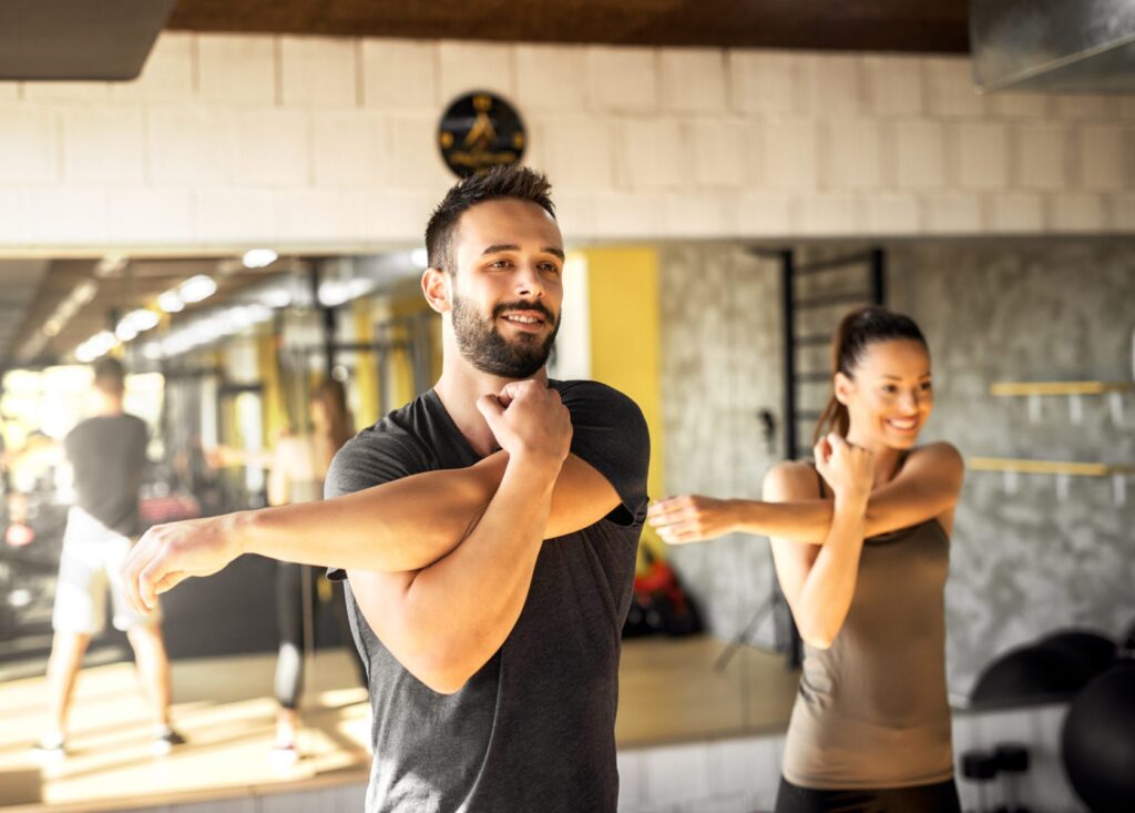 People stretching their shoulders in an exercise room